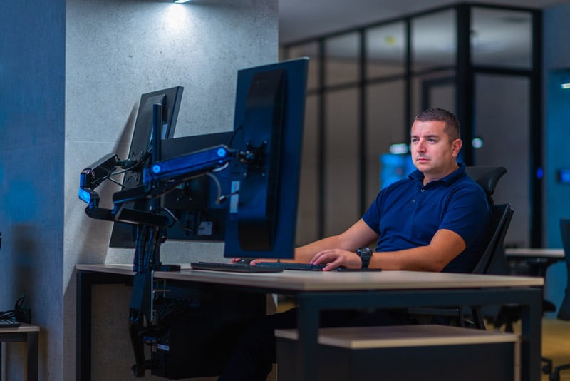 man working on multiple computer screens